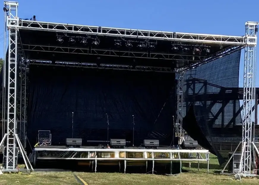 Portable outdoor stage with truss roof, lighting mounts, and sound reinforcement system